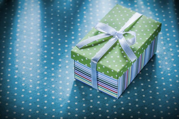 Gift box with ribbon on blue polkadot tablecloth holidays concept