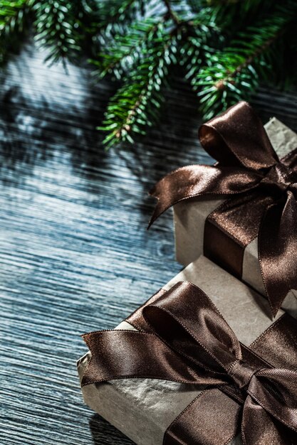 Gift box with ribbon pine branches on vintage wooden board