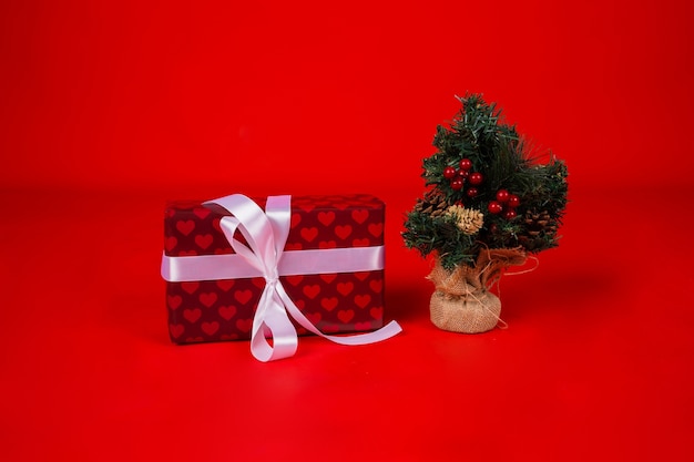 Gift box with a ribbon and a small Christmas tree