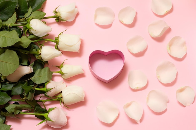 Gift box with rose flowers on the pink background