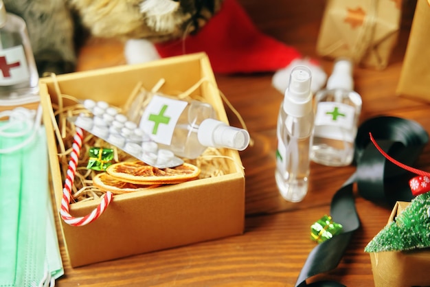 Фото Подарочная коробка с антисептиками, таблетками, леденцами и сушеными апельсинами, елочными украшениями, пушистым котом и меди...