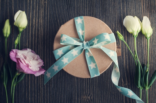 Gift box with star ribbon on dark rustic table