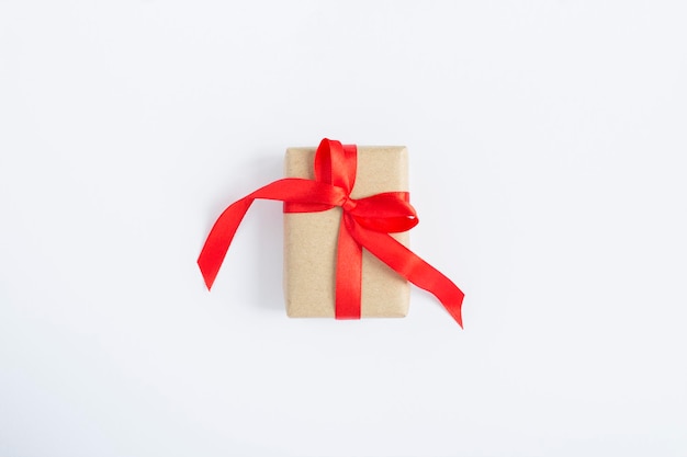 Gift box with tied red bow on the white background. Top view. Copy space.