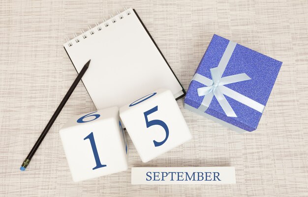 Gift box and wooden calendar with trendy blue numbers, September 15