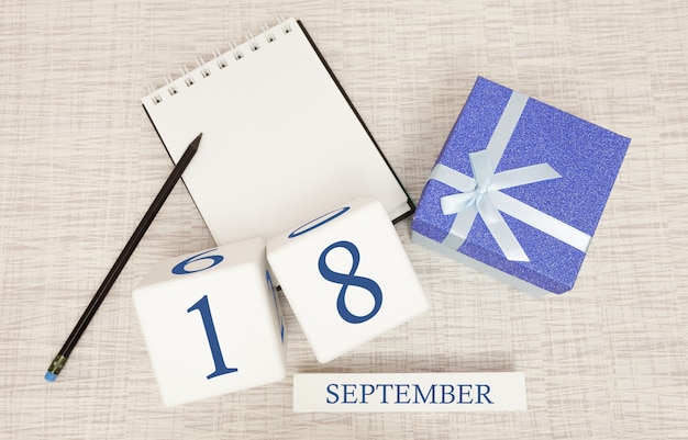 Gift box and wooden calendar with trendy blue numbers, September 18