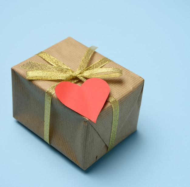 Gift box wrapped in brown paper and red paper heart