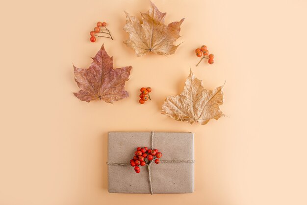 Gift box wrapped in paper with autumn decorations