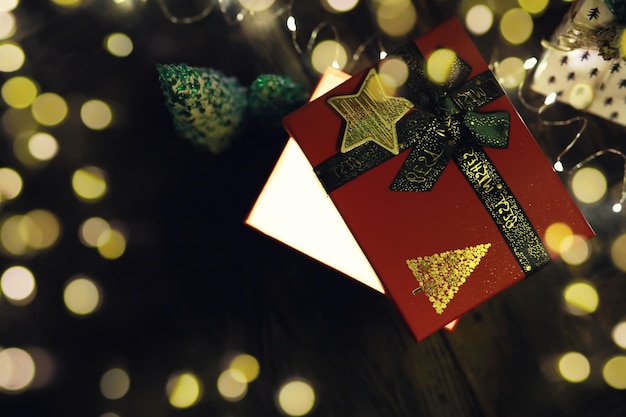 Foto confezioni regalo su uno sfondo bokeh di luci scintillanti di partito regalo di capodanno di lusso regalo di natale sfondo natale con confezione regalo celebrazione di natale