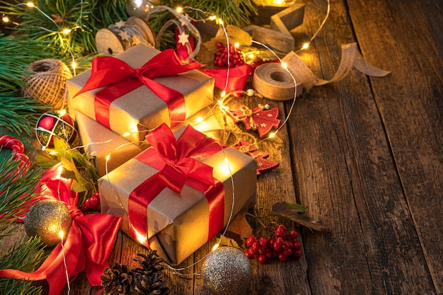 Gift boxes, Christmas toys and burning lights on a wooden background. Merry Christmas and Happy New Year.