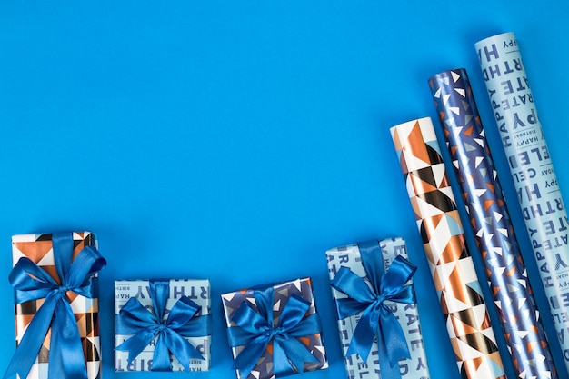 Gift boxes composition on blue background. Flat lay text space.