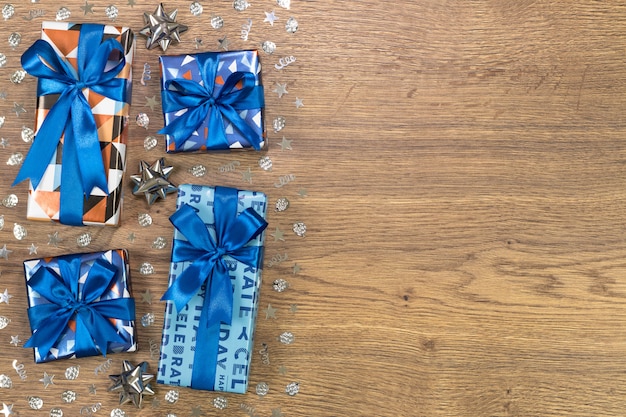 Gift boxes composition on wooden table. Flat lay text space.