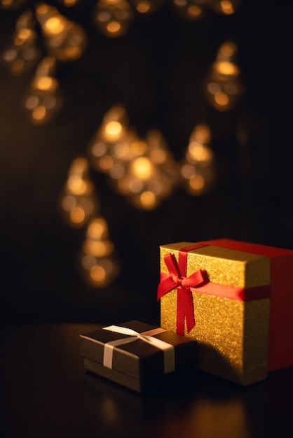 Scatole regalo al buio con luci bokeh di una ghirlanda di natale