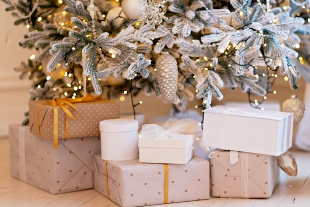 Gift boxes present near the decorated New Years tree. Christmas background. Soft selective focus.