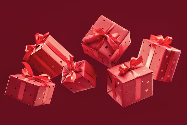 Gift boxes in red paper tied with satin ribbons with bows