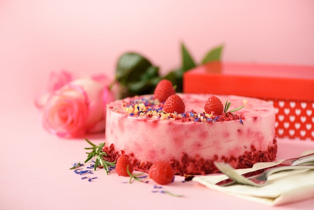 Фото Подарочные коробки, розы, малиновый торт со свежими ягодами, розмарином и сухими цветами. день святого валентина концепция. подарок с любовью