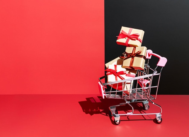 Gift boxes in a shopping cart seasonal sale black and red background red