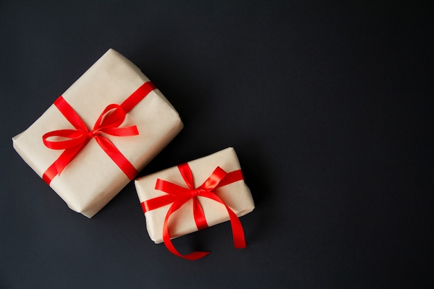 Gift boxes tied with red ribbons on a black