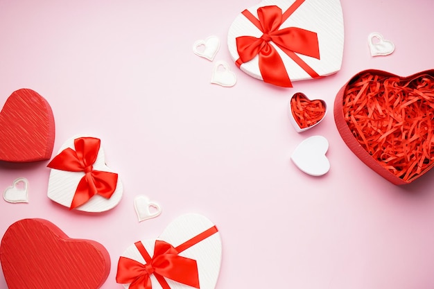 Scatole regalo per san valentino su sfondo rosa con spazio per testo, vista dall'alto.