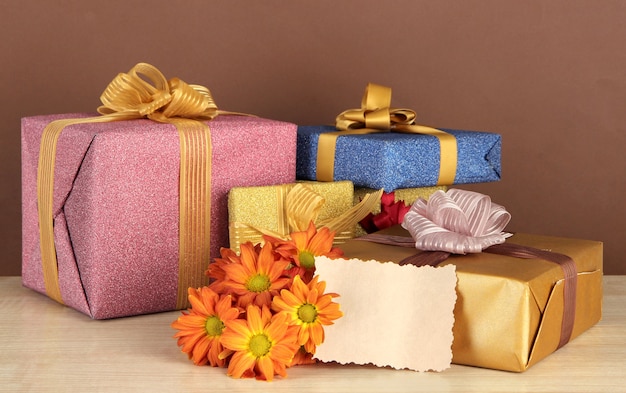 Gift boxes with blank label and flowers on table