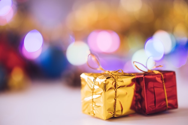 Contenitori di regalo con il bokeh della sfuocatura del fondo della decorazione di natale