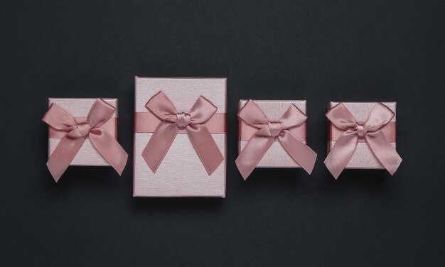 Gift boxes with bow on black background. Composition for Christmas, Black Friday,
 birthday or wedding.