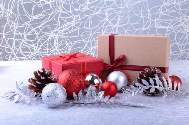 Gift boxes with bow and christmas balls on wood background