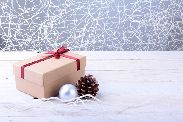 Gift boxes with bow and christmas balls on wood background