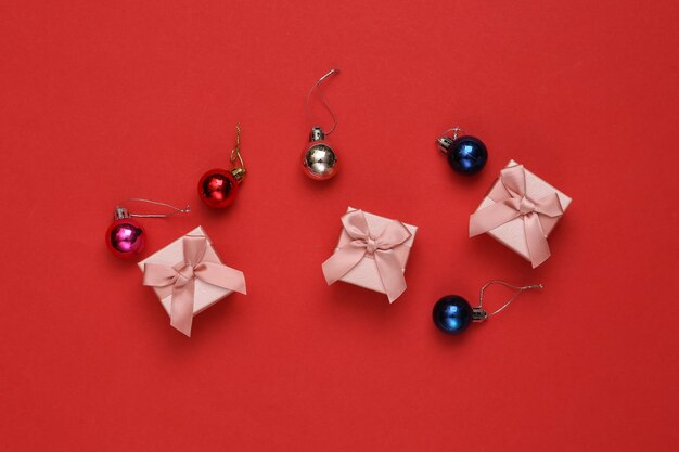 Confezioni regalo con palline di decorazioni di natale su sfondo rosso natale capodanno sfondo