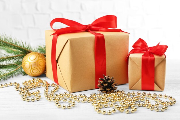 Gift boxes with Christmas tree branch and decor on brick wall background
