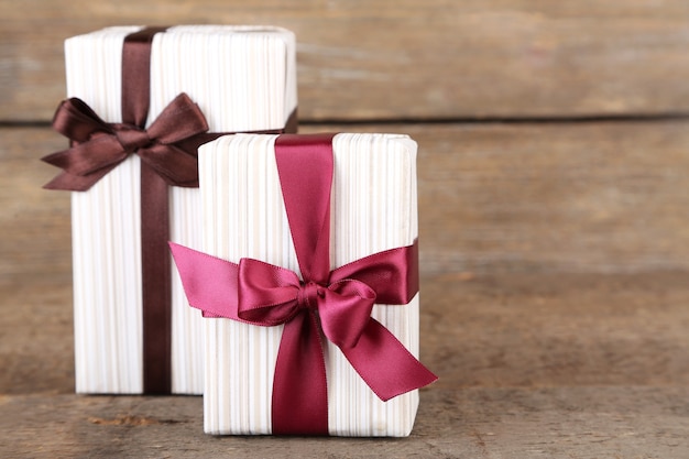 Gift boxes with colorful ribbon on wooden background