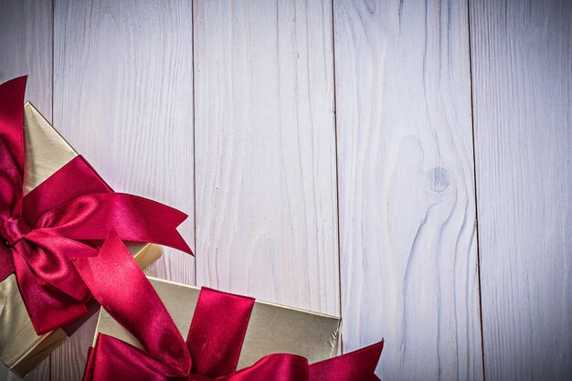 Gift boxes with tied knots on wooden board holidays concept