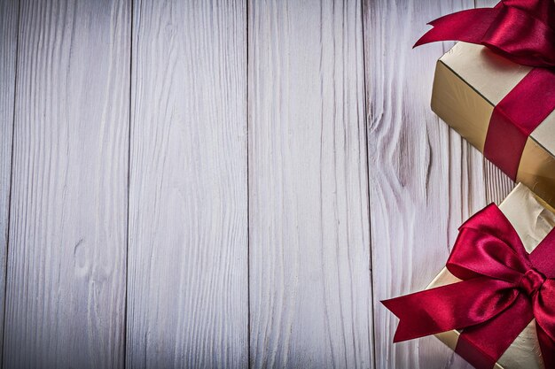 Gift boxes with tied red bows on wood board copy space holidays concept