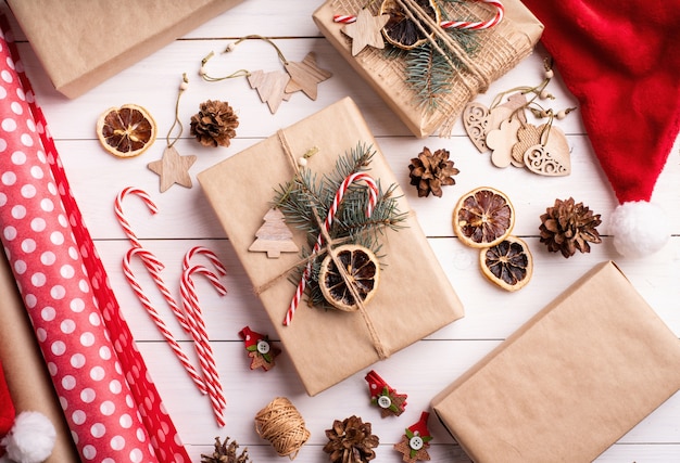 Gift boxes wrapped in craft paper decorated with pine cones and fir tree branches