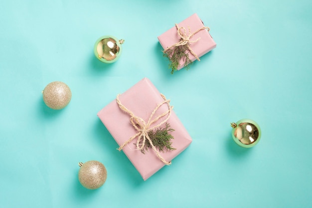 gift boxes wrapped in pink paper and tied with twine line on a blue background Christmas concept