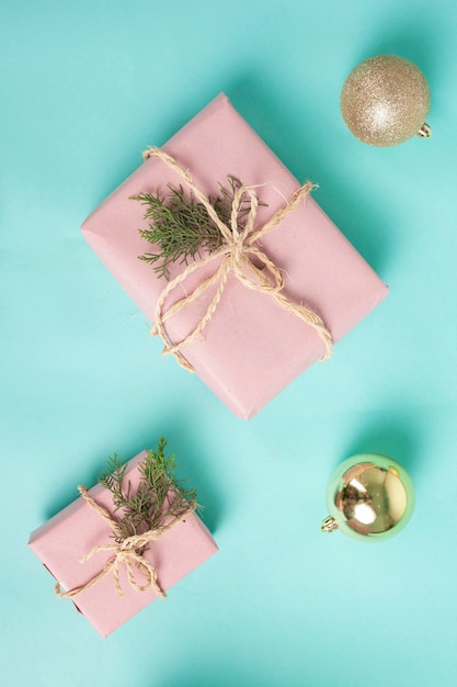 gift boxes wrapped in pink paper and tied with twine line on a blue background Christmas concept
