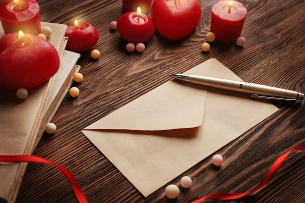 Gift card for Valentine's Day with pen and candles on wooden background