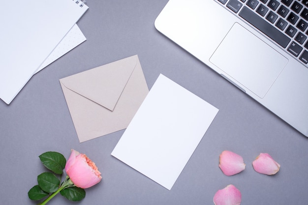 Gift card with pink rose and laptop on gray