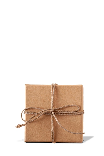 Подарочная картонная коробка, перевязанная шпагатом, стоит на белом фоне с теневой копией пространства