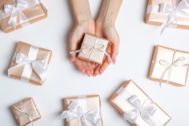 Gift in female hands on a colored background top view