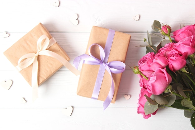 Gift and flowers on a colored background holiday give a gift congratulations