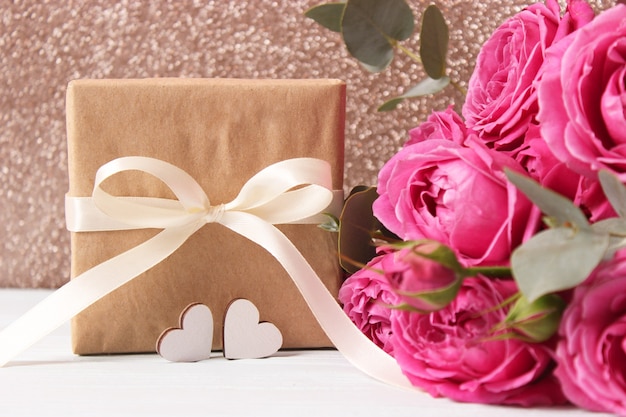 Photo gift and flowers on a colored background holiday give a gift congratulations