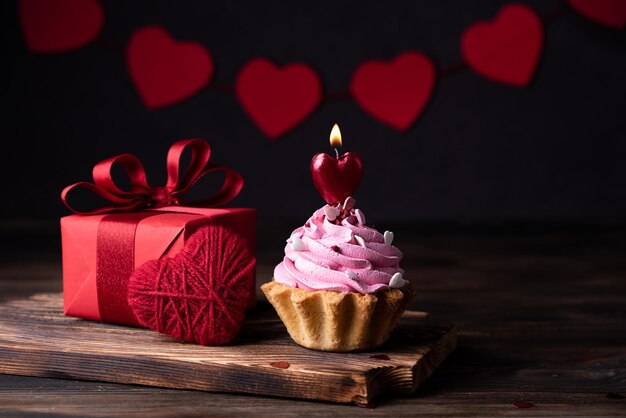 Gift, heart and cake with a burning candle, Valentine's Day and birthday card.