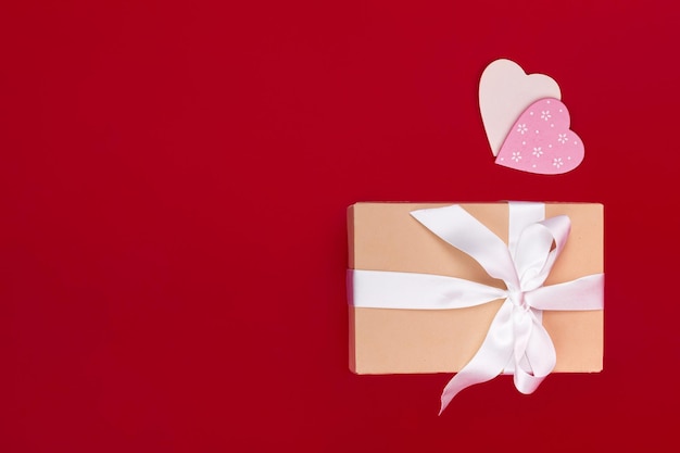 Gift and hearts on red background