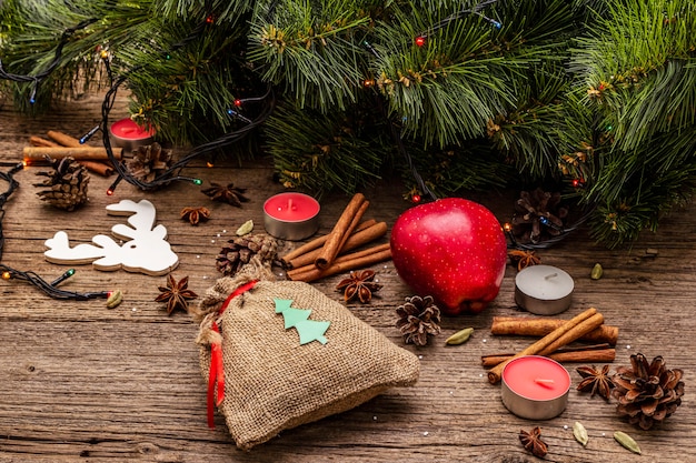 Gift in zak, Nieuwjaarsboom, appel, kaarsen, kruiden, herten, kegels. Natuurdecoraties, vintage houten planken