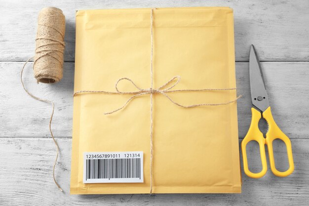 Gift padded envelope with tracking number on wooden background