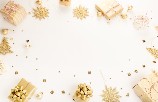 Gift or present gold boxes and stars confetti on white table top view. Flat lay composition for birthday, christmas or wedding.