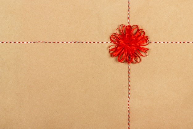 Gift red bow with ribbons on craft paper background