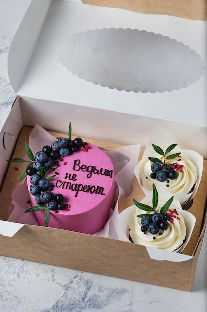 Foto set regalo bento cake e cupcakes i dolci sono decorati con mirtilli freschi traduzione quotle streghe non invecchianoquot