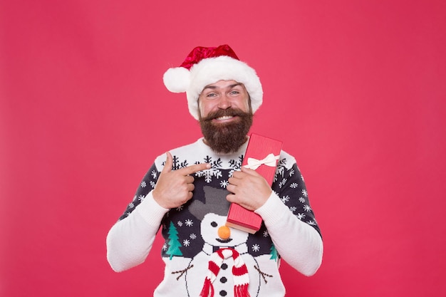 Покупки подарков. Счастливый Санта, как праздничные покупки. Бородатый мужчина указывает на новогодний подарок. Покупки и продажа. Рождественский список покупок. День подарков. Подготовка к Новому году.