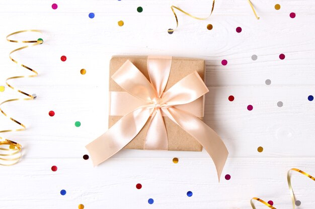 Gift and sparkles of confetti on a colored background top view. minimalism, insta. flatlay . High quality photo